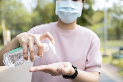 Asian people using alcohol antiseptic gel and wearing prevention mask,prevent against infection of Covid-19 outbreak,woman washing hands with hand sanitizer to avoid contaminating with Corona virus  