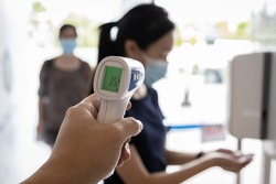 Check body temperature screening using thermometer,prevent people with fever,Coronavirus,cleaning hands with automatic alcohol dispenser,disinfection tunnel,wear face mask at check point for COVID-19