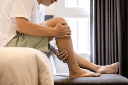 Asian middle aged man have severe cramp his calf of leg,muscle strain,adult male massaging leg with his hands,suffering from muscle cramps,contraction of muscles or tendons,physical injury,health care