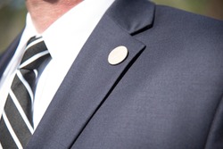Mens suit Lapel pin closeup of tailored business suit and tie corporate meeting