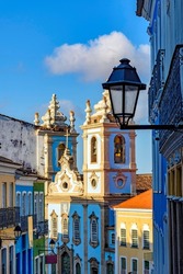 Colorful colonial houses facades and historic church towers in baroque and colonial style with blue sky in the famous Pelourinho district of Salvador, Bahia