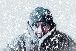 Wintery scene of shivering man in snowstorm or ice storm 