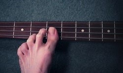 Man playing bass guitar with his feet.