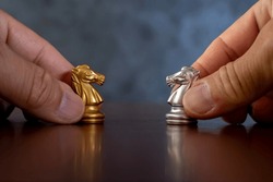 Businessman hands holding horses face to face for business battle. Business leaders and confrontation solving chess board game concept with copy space for your text. 