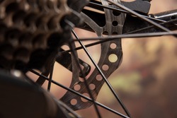 Bicycle details, disc brake and spokes details, dark abstract background, selective focus.