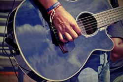 Close-up Of  Guitarist Male Hand And Fingers Who Touches String On The Black Acoustic Six String Guitar. Street Musical Band Play Latin Music