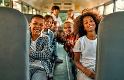 Back to school. Pupils of primary school in school bus. Happy children ready to study.