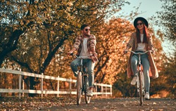 Young couple with bicycles in park in autumn time. 