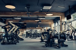 Modern light gym. Sports equipment in gym. Barbells of different weight on rack.