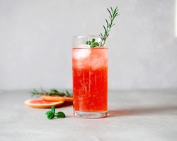 Refreshing drink with grapefruit juice and basil seeds, a sprig of rosemary, ice cubes on a gray background.Detox cocktail. Healthy food. Summer drinks.