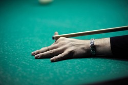 Billiard player arm breaking the pyramid by striking the ball with cue stick, beginning game