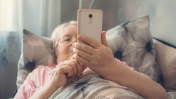 Coronavirus self-isolation advice for over-70s Elders, social isolation and loneliness in older people. Age-group risk for coronavirus. Lonely elderly woman lies in bed at home