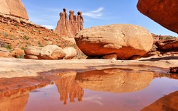Three sisters towers reflection in water, Arches National Park
