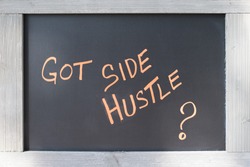 Got Side Hustle Sign handwritten on black board with wood frame for concept of Entrepreneurship