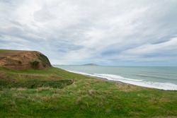 Green Cliffs at Gemstone beach in the Te Waewae Bay with view of Pahia point at distance, Orepuki, The Catlins, Southland, New Zealand