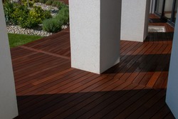 Hardwood Ipe decking, a freshly painted and stained wood deck on the exterior patio of the modern house design