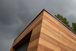 Red cedar wood facade architecture detail low angle view stormy sky background