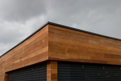 Western red cedar cladding, wood facade, geometric architecture detail against dark sky