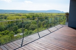 Apartment balcony scenery view with exotic grooved cumaru wood decking and modern glass railing