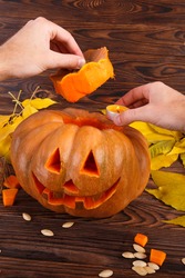 A big autumn halloween pumpkin with leaves on a wooden background. Halloween concept