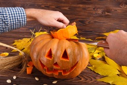 A big autumn halloween pumpkin with leaves on a wooden background. Halloween concept