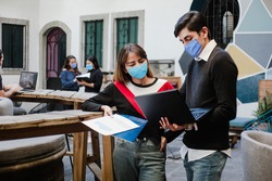 Latin people teamwork working in coworking while wearing face mask for social distancing in new normal situation preventing the infection of corona virus or covid-19, Mexican Coworkers in Mexico