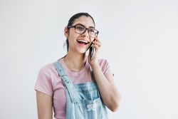 Young latin woman student calling by phone on gray background in Latin America