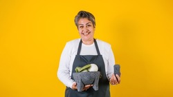 Portrait of hispanic woman middle aged cooking and holding mexican mortar with sauce ingredients in Mexico Latin America
