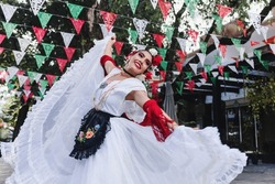 Latin woman wearing traditional Mexican dress traditional from Veracruz Mexico Latin America, young hispanic people in independence day or cinco de mayo parade or cultural Festival