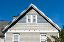 Victorian mansion gable roof with covered with blue and gray shake and shingle against blue sky