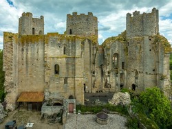 Aerial view of Bourbon-L'Archambault castle of the royal family ruined during the revolution, with three circular towers , Gothic arches surviving on a hilltop over the sleepy small French town 