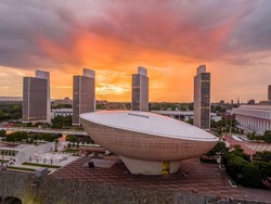 Stunning after the rain colorful sunset over The Egg performing art center and New York State government buildings in Albany with bright orange, red, purple sky