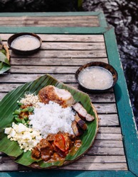 Meal set of various traditional Filippino Food,  Pakbet on banana leaves and wooden table, top view