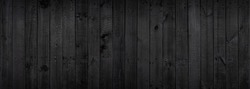Black wood texture background coming from natural tree. The wooden panel has a beautiful dark pattern that is empty.