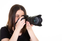 Young woman with black professional digital SLR camera on white background