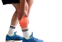 Man in sport clothes holding leg muscle pain and numbness from muscle cramps isolated on white background with copy space for text. Calf muscle pain in runner.
