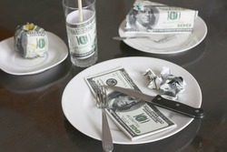 Rising food prices, high cost of living concept, eating foot made out of money - fake 100 dollar bills
