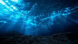Underwater photo of rays light in the deep blue ocean.