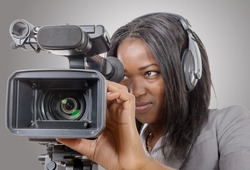 a young African American women with professional video camera and headphone