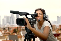 a young African American women with professional video camera and headphone 