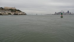 Alcatraz island in San Francisco Bay, California USA. Federal prison for gangsters on rock, foggy weather. Historic jail, cliff in misty cloudy harbor. Gaol for punishment and imprisonment for crime.