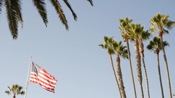 Palms and american flag, Los Angeles, California USA. Summertime aesthetic of Santa Monica Venice Beach. Star-Spangled Banner, Stars and Stripes. Atmosphere of patriotism in Hollywood. LA vibes.