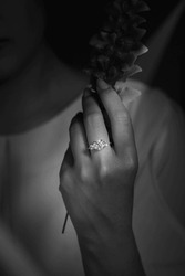 Closeup of female hand with diamond engagement ring black and white