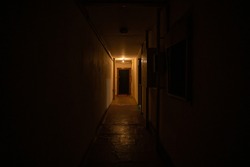Empty dark corridor with light at the end.