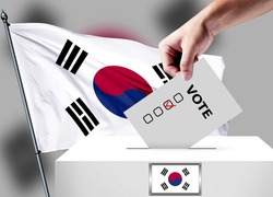 Elections in the Korea South. The hand that puts the game in the ballot box. Korea South flags in the background. Country flag election.