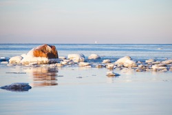Ice-covered granite stones in the bay of the Gulf of Bothnia