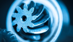 Beautiful close-up of steel gearwheel. Abstract industrial background with cogwheels in blue color.