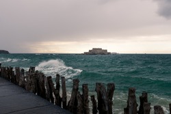 The beach and Fort National during high tide in Saint Malo (Bretagne, France) on a stormy, cloudy day in summer