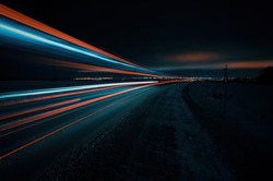 Long exposure of a road with light trails of passing vehicles, glowing sky