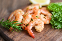 Salad shrimp grilled delicious seasoning spices on wooden cutting board background appetizing cooked shrimps baked prawns , Seafood shelfish with rosemary lemon and lettuce